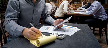 Person working with documents and calculator.