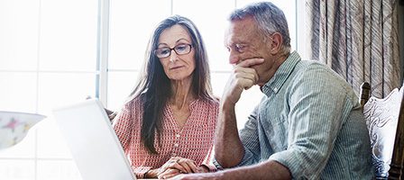 Elderly couple using a laptop together