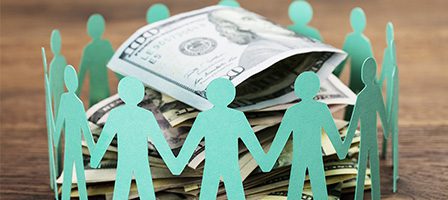 Paper cutouts surrounding dollar bills