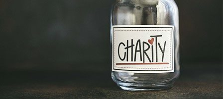Empty glass jar labeled "Charity