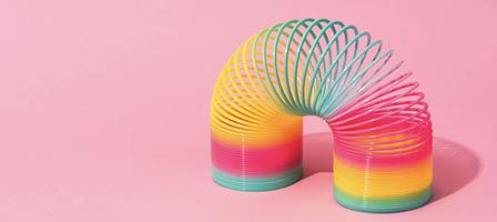 Colorful slinky on pink background
