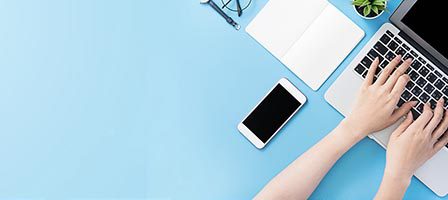 Laptop and smartphone on blue desk