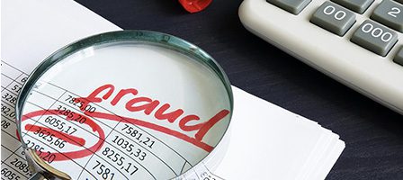 Magnifying glass over financial fraud document