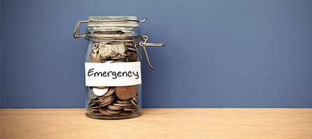 Savings jar for emergencies on wooden table