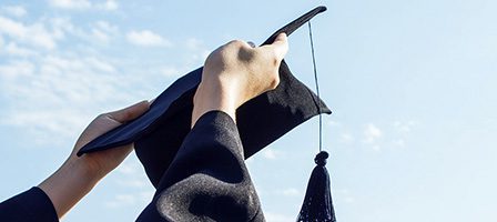 Hands raising cap in celebration