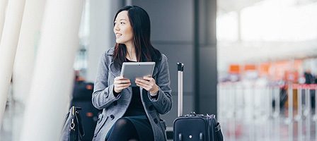 Airport traveler using tablet while waiting