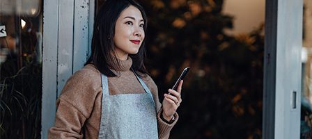 Smiling woman standing with phone in hand