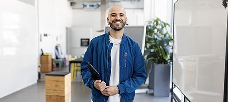 Bald man in blue jacket indoors