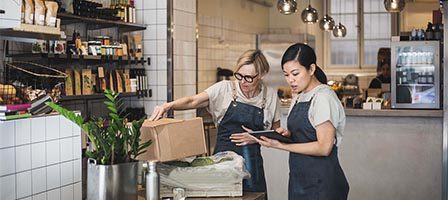 Two workers managing inventory in cafe