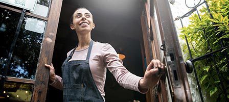 Happy shop owner welcoming customers