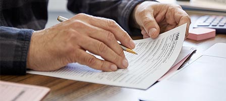 Person reading a printed form at desk