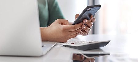 Person using smartphone at work desk
