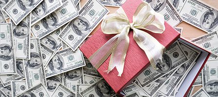 Money surrounding a festive gift box