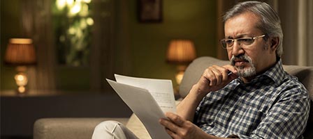 Older man focused on reading papers