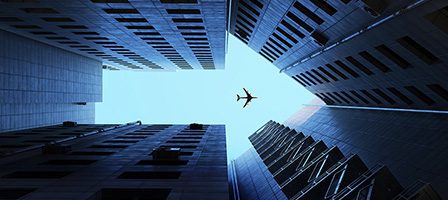 Plane above city buildings