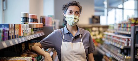 Person in apron at supermarket aisle