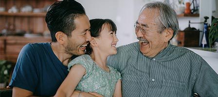 Father, daughter, and grandfather smiling warmly
