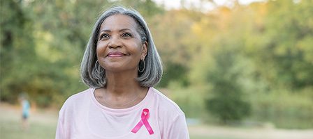 Senior woman wearing pink breast cancer ribbon
