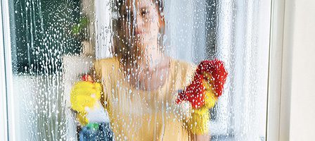 Woman cleaning a glass surface