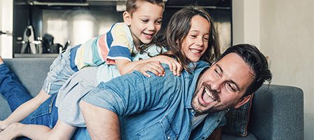 Kids laughing while piled on dad's back
