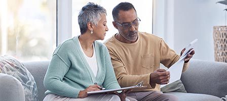 Mature pair examining financial papers indoors.