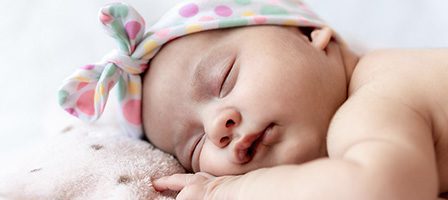 Sleeping baby with colorful headband