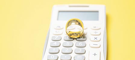 Wedding ring placed on white calculator
