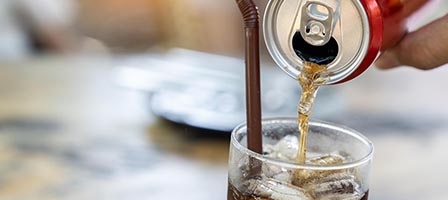 Carbonated drink filling an ice-filled glass