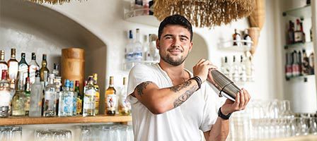 Man making drinks behind a bar counter