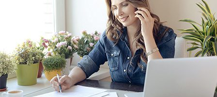 Woman multitasking with laptop and phone