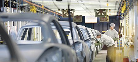 Car factory with assembly workers