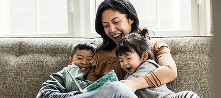 Mother reading with children on couch