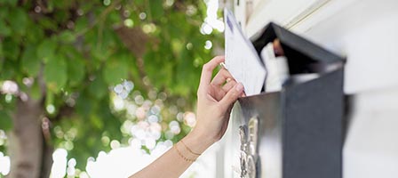 Person mailing letter outdoors