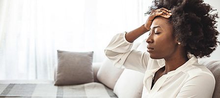 Woman holding head, looking stressed
