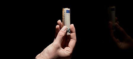 Person displaying a rolled euro
