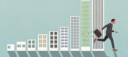 Businessman ascending bar chart buildings
