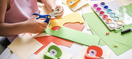 Kid creating art with paper supplies