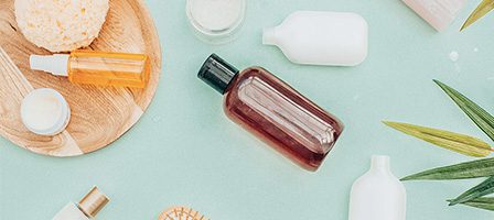 Assorted skincare bottles and jars flat lay