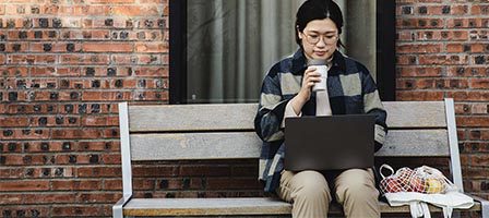 Woman sitting on bench using laptop