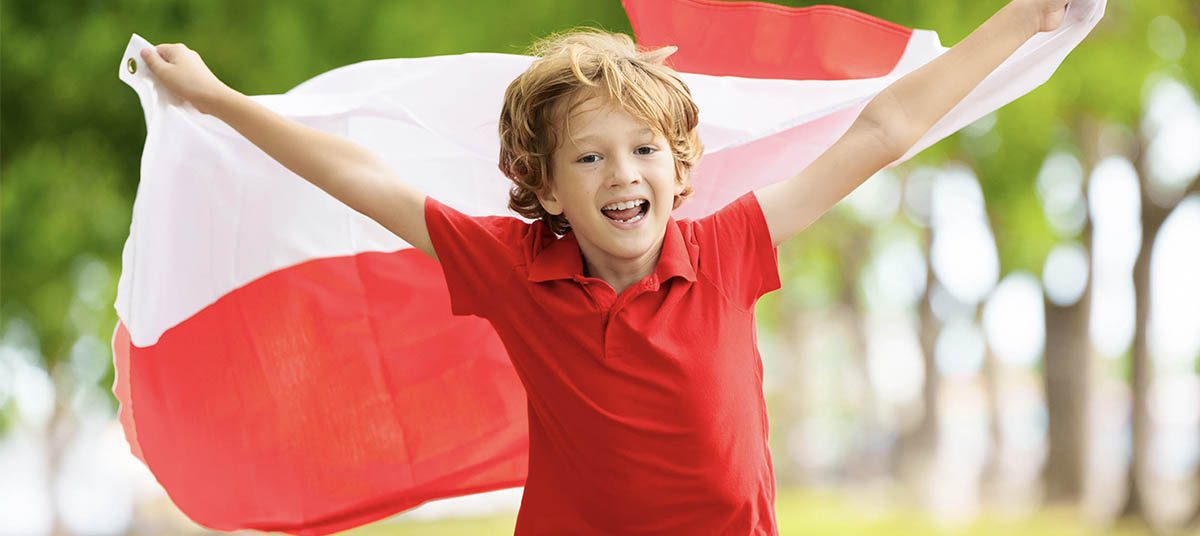Child holding Polish flag outdoors