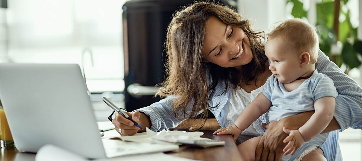 Mother working with baby in arms