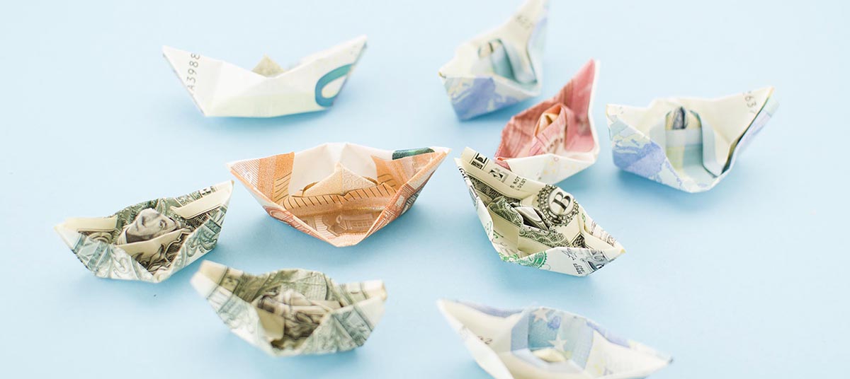 Paper boats folded from money notes