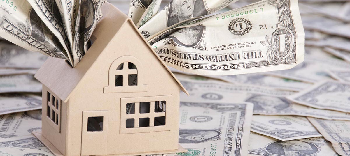 Money flowing from miniature house