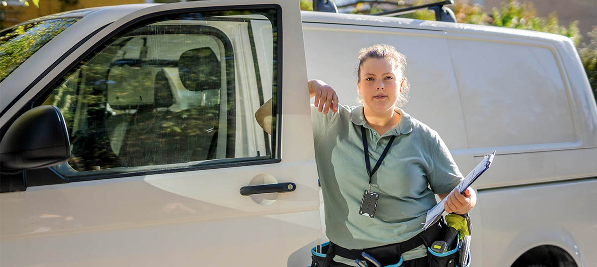 Person with tool belt beside vehicle