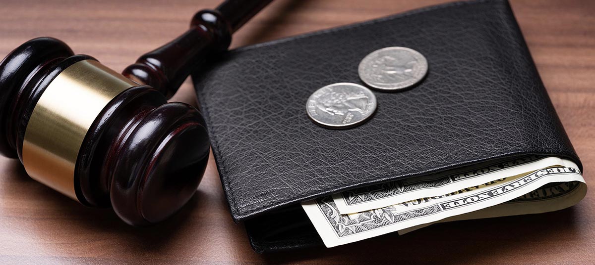 Gavel beside wallet with coins and bills