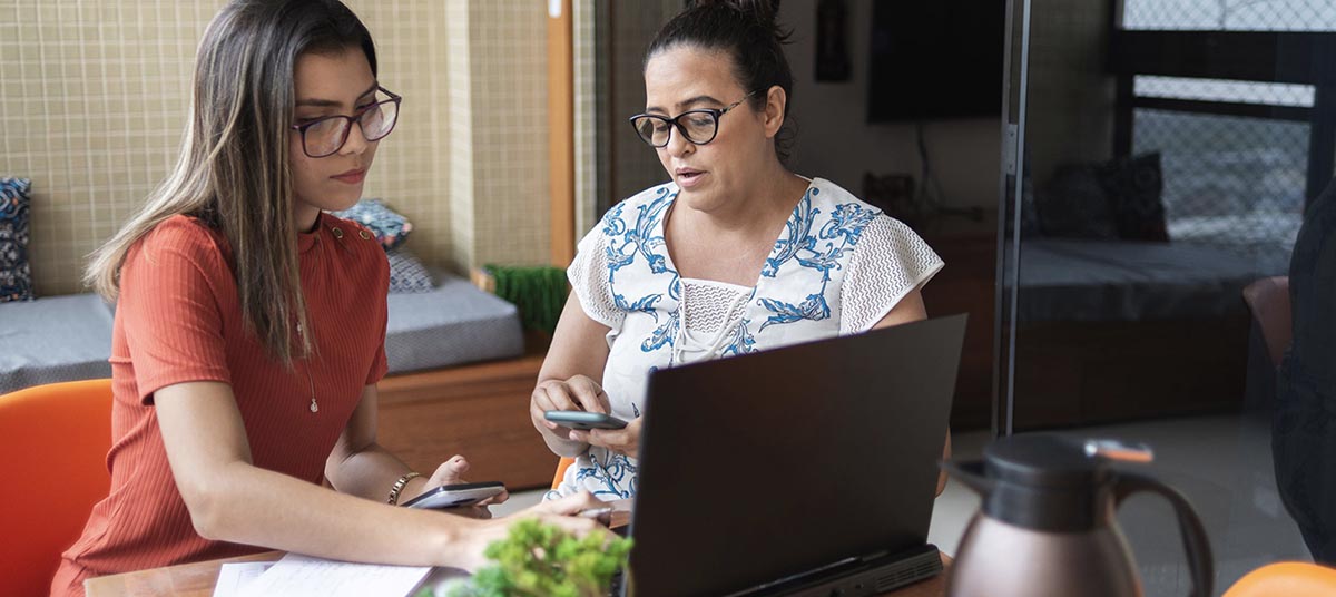 Women collaborating over coffee and documents