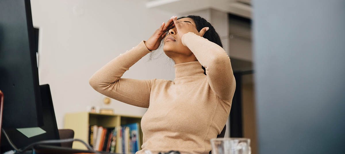 Frustrated person holding head in hands