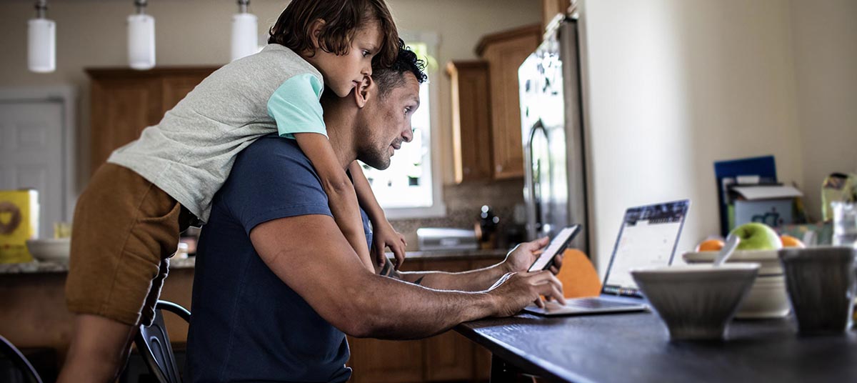 Father working with child in kitchen