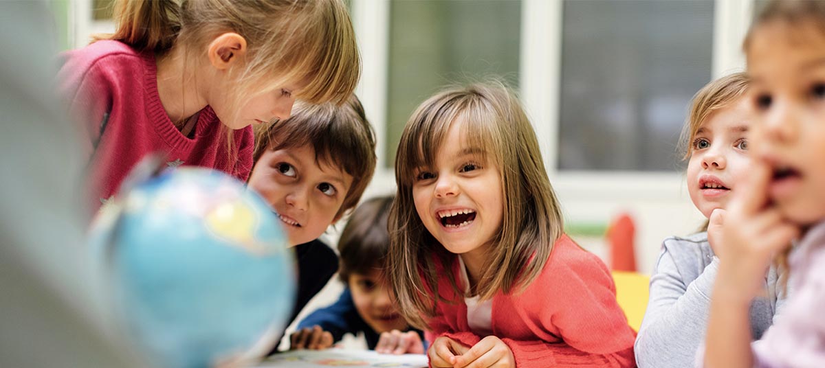 Children gathered around a globe