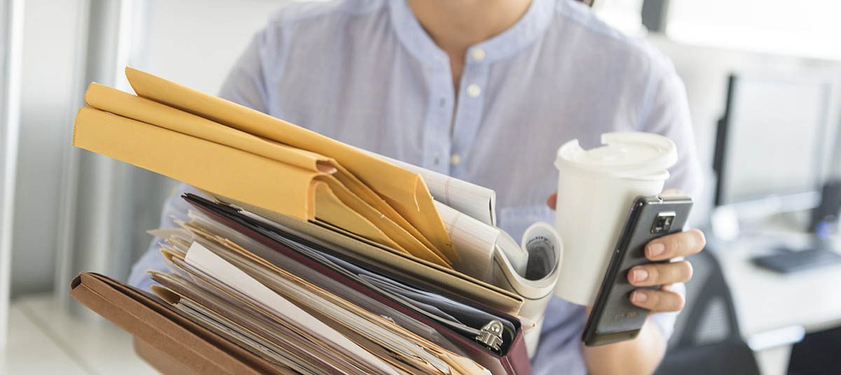 Person carrying documents and coffee